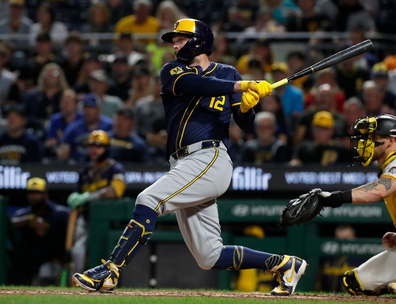 Sep 25, 2024; Pittsburgh, Pennsylvania, USA;  Milwaukee Brewers first baseman Rhys Hoskins (12) hits a single against the Pittsburgh Pirates during the seventh inning at PNC Park. Mandatory Credit: Charles LeClaire-Imagn Images