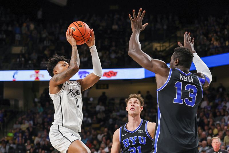 Feb 1, 2025; Orlando, Florida, USA; UCF Knights guard Jordan Ivy-Curry (0) goes to the basket against Brigham Young Cougars center Keba Keita (13) during the first half at Addition Financial Arena. Mandatory Credit: Mike Watters-Imagn Images