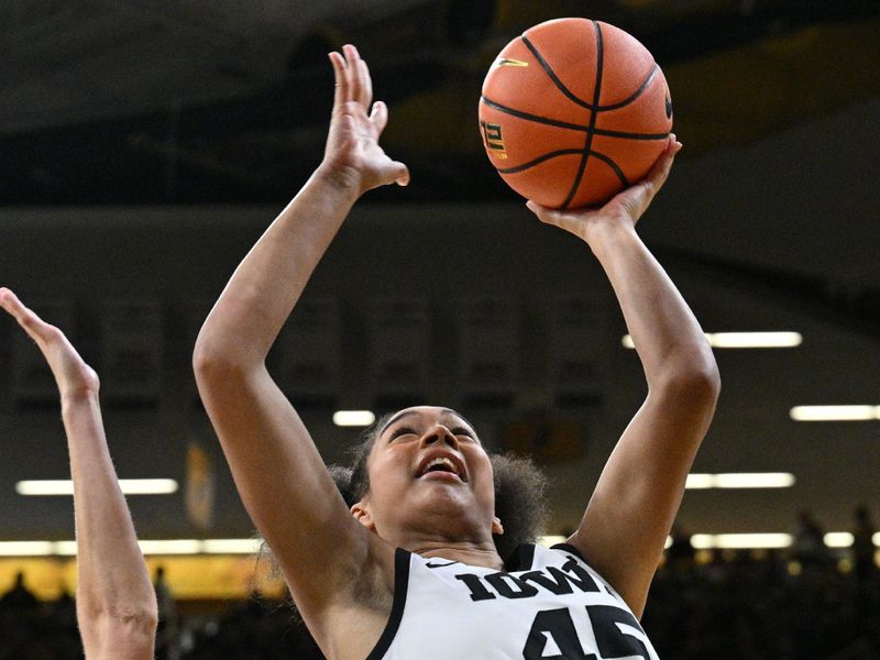 Feb 8, 2024; Iowa City, Iowa, USA; Iowa Hawkeyes forward Hannah Stuelke (45) goes to the basket during the second half as Penn State Nittany Lions guard Makenna Marisa (20) defends at Carver-Hawkeye Arena. Mandatory Credit: Jeffrey Becker-USA TODAY Sports