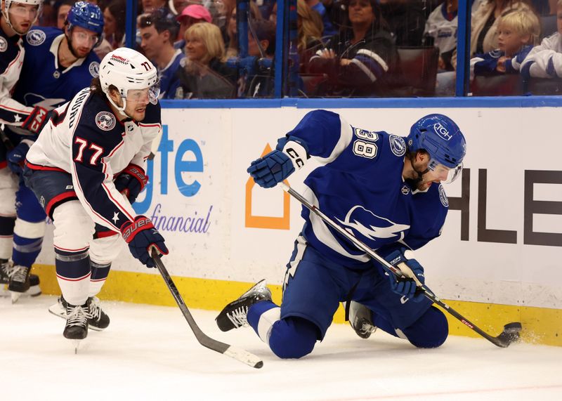 Apr 9, 2024; Tampa, Florida, USA; Tampa Bay Lightning left wing Brandon Hagel (38) defends the puck as Columbus Blue Jackets defenseman Nick Blankenburg (77) attempts to defend during the third period at Amalie Arena. Mandatory Credit: Kim Klement Neitzel-USA TODAY Sports