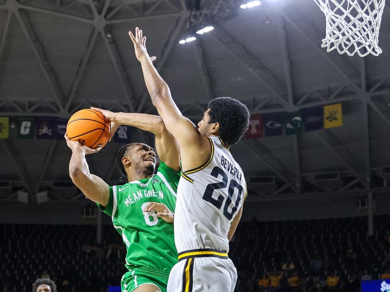 Jan 29, 2025; Wichita, Kansas, USA; North Texas Mean Green guard Tyran Mason (0) shoots the ball over Wichita State Shockers guard Harlond Beverly (20) during the first half at Charles Koch Arena. Mandatory Credit: William Purnell-Imagn Images