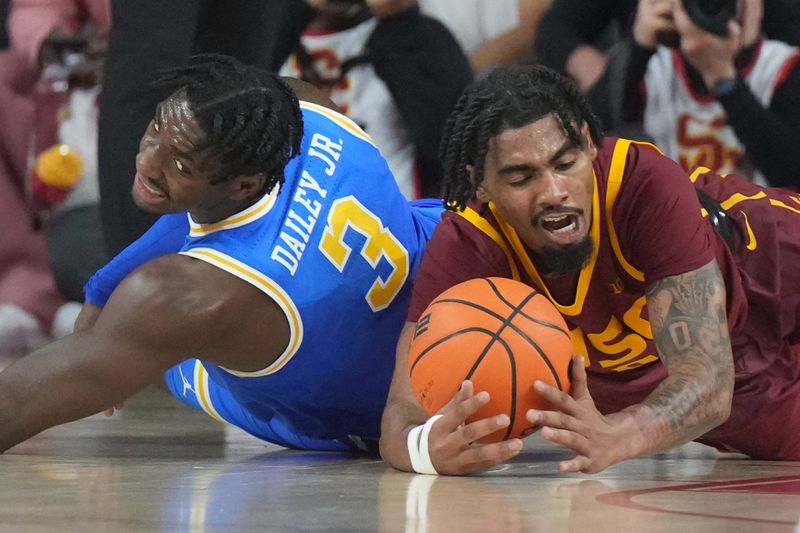 Jan 27, 2025; Los Angeles, California, USA; Southern California Trojans forward Saint Thomas (0) and UCLA Bruins guard Eric Dailey Jr. (3) reach for the ball in the second half at the Galen Center. Mandatory Credit: Kirby Lee-Imagn Images