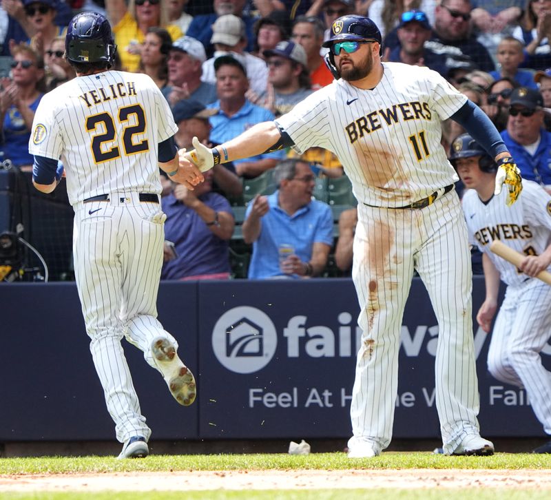 May 28, 2023; Milwaukee, Wisconsin, USA; Milwaukee Brewers left fielder Christian Yelich (22) is congratulated by first baseman Rowdy Tellez (11) after scoring on a single by catcher William Contreras during the first inning at American Family Field. Mandatory Credit: Mark Hoffman/Milwaukee Journal Sentinel-USA TODAY Sports