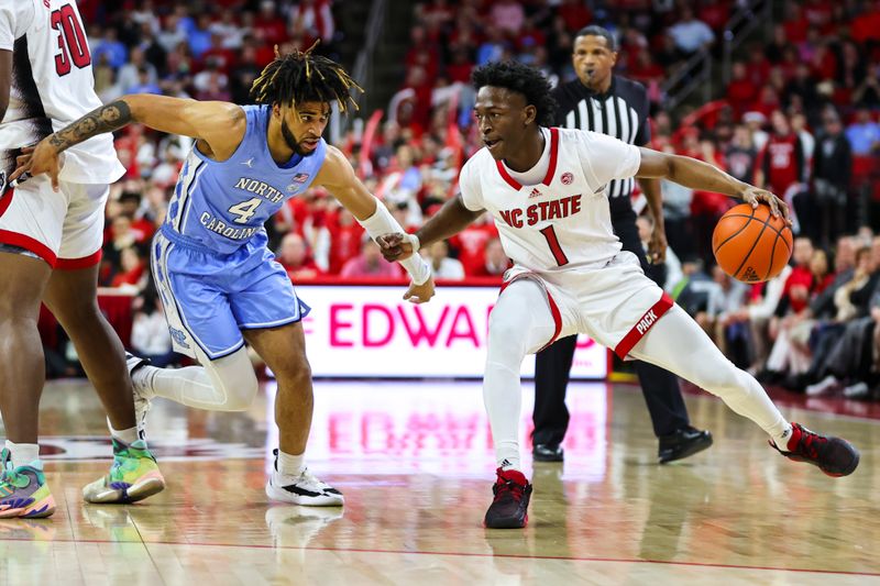 Feb 19, 2023; Raleigh, North Carolina, USA; North Carolina State Wolfpack guard Jarkel Joiner (1) dribbles against Carolina Tar Heels guard R.J. Davis (4) during the first half of the game at PNC Arena. Mandatory Credit: Jaylynn Nash-USA TODAY Sports