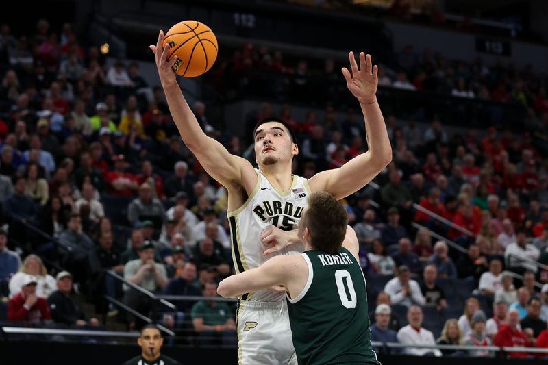 Mar 15, 2024; Minneapolis, MN, USA; Purdue Boilermakers center Zach Edey (15) catches a rebound as Michigan State Spartans forward Jaxon Kohler (0) defends during the first half at Target Center. Mandatory Credit: Matt Krohn-USA TODAY Sports