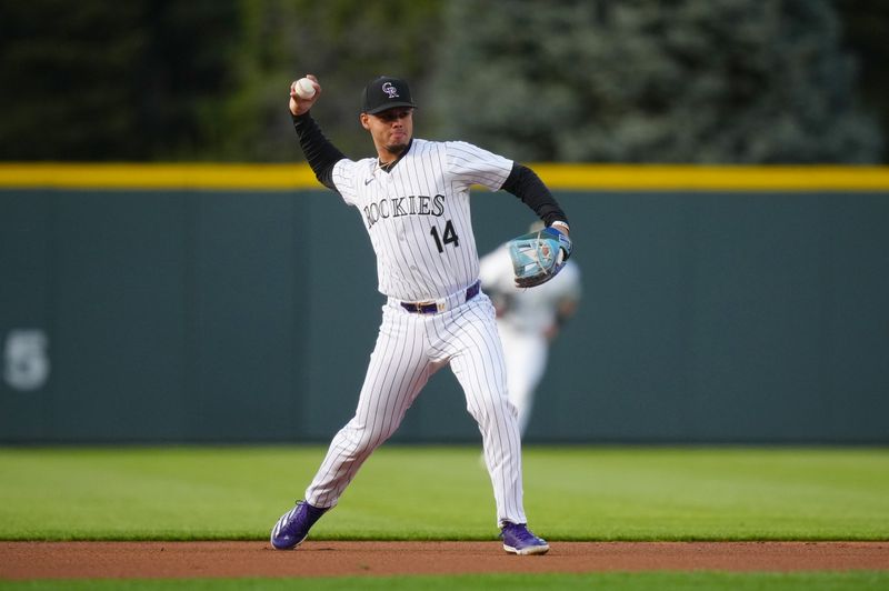 Apr 21, 2024; Denver, Colorado, USA; Colorado Rockies shortstop Ezequiel Tovar (14) fields the ball in the first inning against the Seattle Mariners at Coors Field. Mandatory Credit: Ron Chenoy-USA TODAY Sports