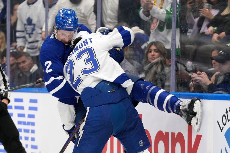 Oct 21, 2024; Toronto, Ontario, CAN; Toronto Maple Leafs defenseman Simon Benoit (2) and Tampa Bay Lightning forward Michael Eyssimont (23) battle along the boards during the second period at Scotiabank Arena. Mandatory Credit: John E. Sokolowski-Imagn Images