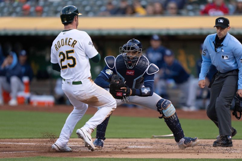 Jun 14, 2023; Oakland, California, USA;  Tampa Bay Rays catcher Christian Bethancourt (14) tags out Oakland Athletics left fielder Brent Rooker (25) during the second inning at Oakland-Alameda County Coliseum. Mandatory Credit: Stan Szeto-USA TODAY Sports