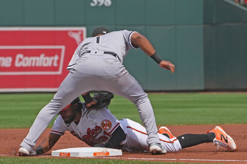 Aug 30, 2023; Baltimore, Maryland, USA; Baltimore Orioles outfielder Cedric Mullins (31) slides safely under the tag of Chicago White Sox third baseman Elvis Andrus (1) in the first inning at Oriole Park at Camden Yards. Mandatory Credit: Mitch Stringer-USA TODAY Sports