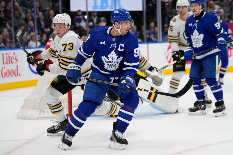 Mar 4, 2024; Toronto, Ontario, CAN; Toronto Maple Leafs forward John Tavares (91) and Boston Bruins defenseman Charlie McAvoy (73) look for the puck during the third period at Scotiabank Arena. Mandatory Credit: John E. Sokolowski-USA TODAY Sports