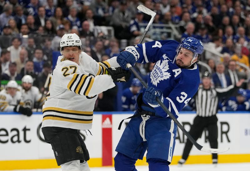 Apr 24, 2024; Toronto, Ontario, CAN; Toronto Maple Leafs forward Auston Matthews (34) and Boston Bruins defenseman Hampus Lindholm (27) battle for position during the first period of game three of the first round of the 2024 Stanley Cup Playoffs at Scotiabank Arena. Mandatory Credit: John E. Sokolowski-USA TODAY Sports