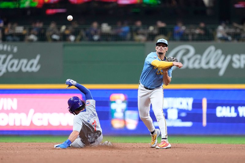 Jun 28, 2024; Milwaukee, Wisconsin, USA;  Milwaukee Brewers shortstop Willy Adames (27) turns a double play as Chicago Cubs shortstop Dansby Swanson (7) slides into second base during the fourth inning at American Family Field. Mandatory Credit: Jeff Hanisch-USA TODAY Sports