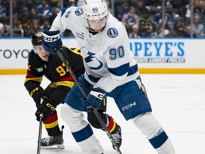 Mar 19, 2026; Vancouver, British Columbia, CAN; Vancouver Canucks forward Liam Ohgren (92) stick checks Tampa Bay Lightning defenseman J.J. Moser (90) in the second period at Rogers Arena. Mandatory Credit: Bob Frid-Imagn Images