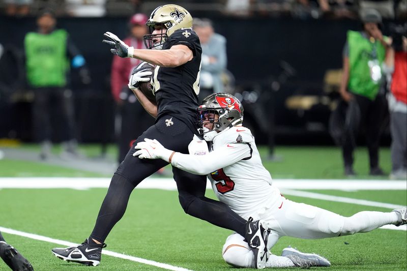 New Orleans Saints tight end Foster Moreau, left, runs against Tampa Bay Buccaneers linebacker Joe Tryon-Shoyinka during the first half of an NFL football game in New Orleans, Sunday, Oct. 13, 2024. (AP Photo/Michael Conroy)