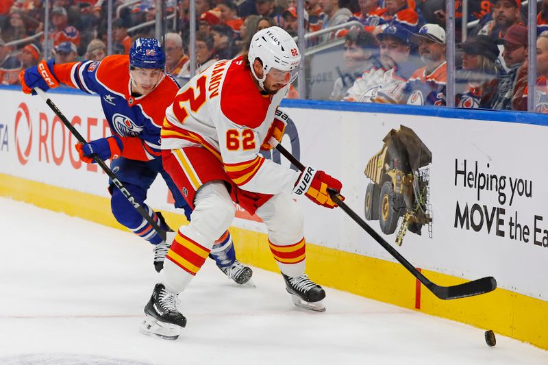 Oct 13, 2024; Edmonton, Alberta, CAN; Calgary Flames defensemen Daniil Miromanov (62) tries to clear a puck in front of Edmonton Oilers forward Ryan Nugent-Hopkins (93) during the first period at Rogers Place. Mandatory Credit: Perry Nelson-Imagn Images