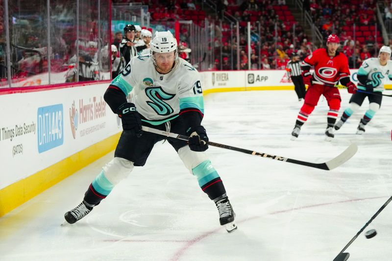 Oct 26, 2023; Raleigh, North Carolina, USA; Seattle Kraken left wing Jared McCann (19) takes a back hand shot against the Carolina Hurricanes during the second period at PNC Arena. Mandatory Credit: James Guillory-USA TODAY Sports