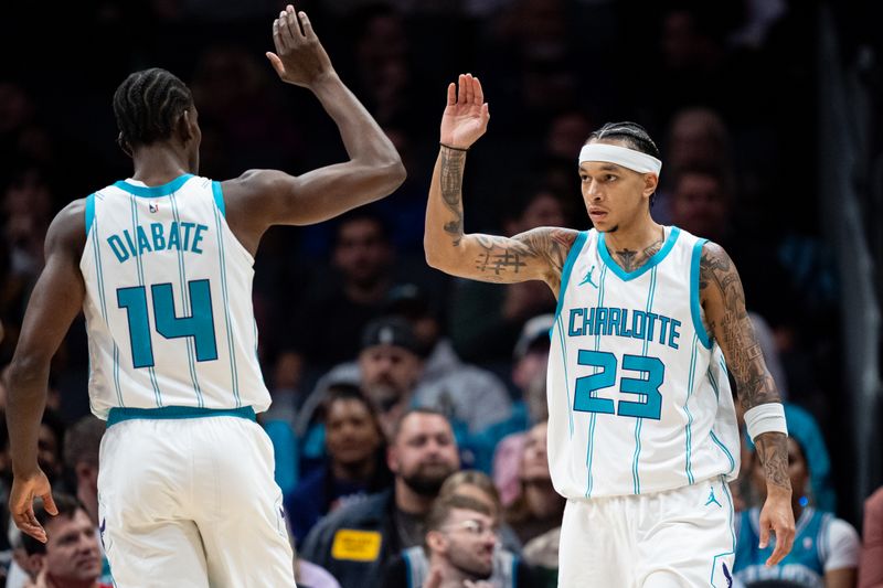 CHARLOTTE, NORTH CAROLINA - OCTOBER 30: Tre Mann #23 of the Charlotte Hornets celebrates with Moussa Diabate #14 in the first quarter during their game against the Toronto Raptors at Spectrum Center on October 30, 2024 in Charlotte, North Carolina. NOTE TO USER: User expressly acknowledges and agrees that, by downloading and or using this photograph, User is consenting to the terms and conditions of the Getty Images License Agreement. (Photo by Jacob Kupferman/Getty Images)