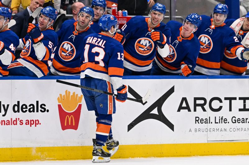 Mar 23, 2024; Elmont, New York, USA;  New York Islanders center Mathew Barzal (13) celebrates his goal against the Winnipeg Jets during the second period at UBS Arena. Mandatory Credit: Dennis Schneidler-USA TODAY Sports