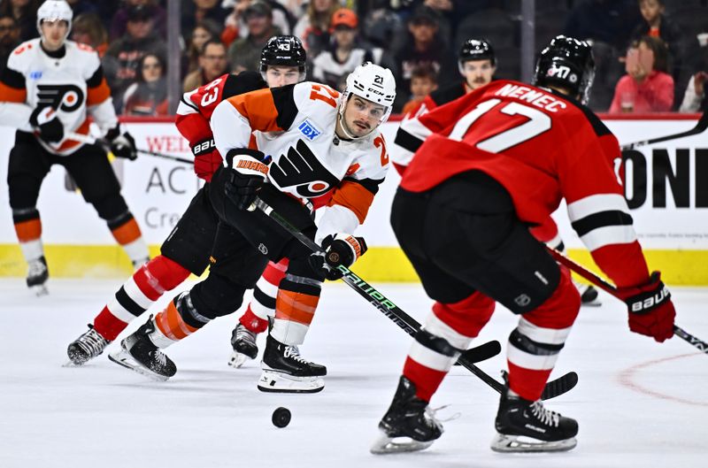 Apr 13, 2024; Philadelphia, Pennsylvania, USA; Philadelphia Flyers center Scott Laughton (21) passes the puck across New Jersey Devils defenseman Simon Nemec (17) in the first period at Wells Fargo Center. Mandatory Credit: Kyle Ross-USA TODAY Sports