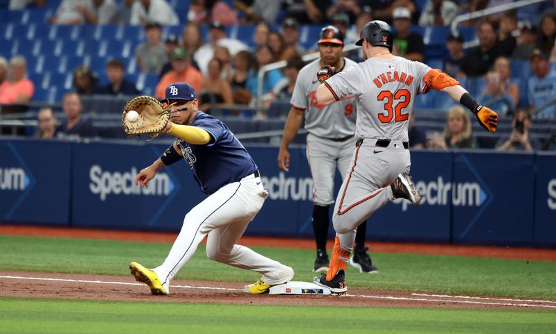 Jun 10, 2024; St. Petersburg, Florida, USA;  Baltimore Orioles first base Ryan O'Hearn (32) is safe at first base as Tampa Bay Rays first baseman Isaac Paredes (17) attempted to tag him out during the first inning at Tropicana Field. Mandatory Credit: Kim Klement Neitzel-USA TODAY Sports