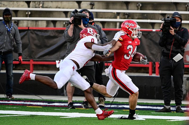 Dec 12, 2020; College Park, Maryland, USA;  Maryland Terrapins running back Jake Funk (34) runs pass Rutgers Scarlet Knights defensive back Christian Izien (0) for a second half touchdown at Capital One Field at Maryland Stadium. Mandatory Credit: Tommy Gilligan-USA TODAY Sports