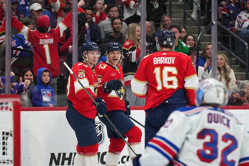 Dec 29, 2023; Sunrise, Florida, USA; Florida Panthers center Sam Reinhart (13) celebrates his goal on New York Rangers goaltender Jonathan Quick (32) with center Carter Verhaeghe (23) and center Aleksander Barkov (16) during the second period at Amerant Bank Arena. Mandatory Credit: Jasen Vinlove-USA TODAY Sports