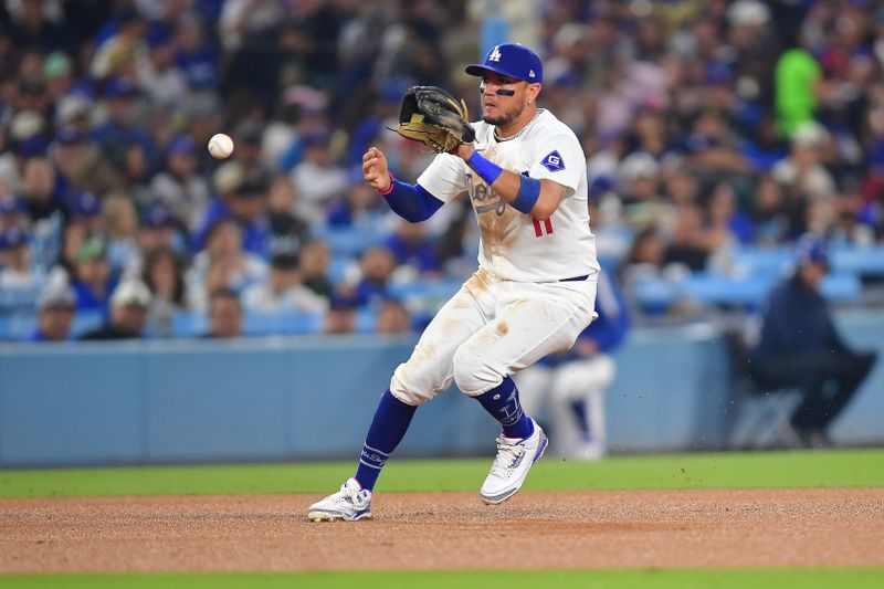 Sep 24, 2024; Los Angeles, California, USA; Los Angeles Dodgers shortstop Miguel Rojas (11) fields the ground ball of San Diego Padres third baseman Manny Machado (13) during the sixth inning at Dodger Stadium. Mandatory Credit: Gary A. Vasquez-Imagn Images