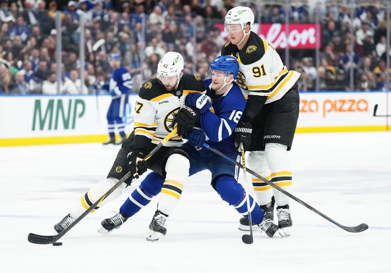 Nov 5, 2024; Toronto, Ontario, CAN; Toronto Maple Leafs center Steven Lorentz (18) battles for the puck with Boston Bruins center Mark Kastelic (47) and defenseman Nikita Zadorov (91) during the third period at Scotiabank Arena. Mandatory Credit: Nick Turchiaro-Imagn Imagess