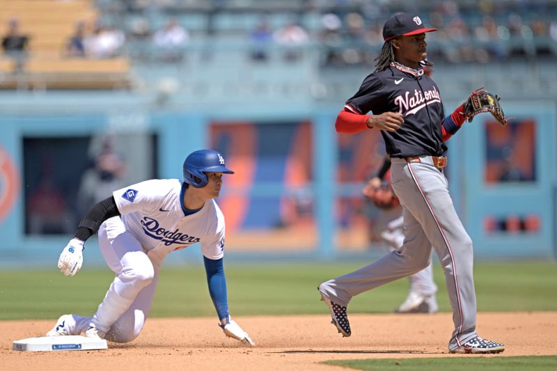 Apr 17, 2024; Los Angeles, California, USA; Los Angeles Dodgers designated hitter player Shohei Ohtani (17) steals second in front of Washington Nationals shortstop CJ Abrams (5) in the eighth inning at Dodger Stadium. Mandatory Credit: Jayne Kamin-Oncea-USA TODAY Sports