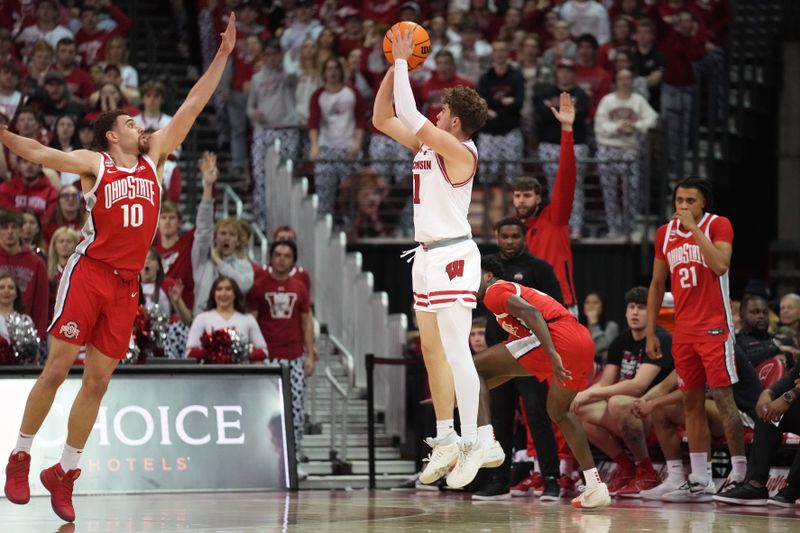 Feb 13, 2024; Madison, Wisconsin, USA;  Wisconsin Badgers guard Max Klesmit (11) scores against Ohio State Buckeyes forward Jamison Battle (10) during the first half at the Kohl Center. Mandatory Credit: Kayla Wolf-USA TODAY Sports