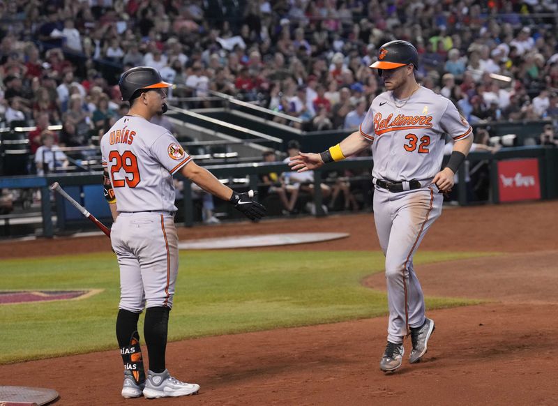 Sep 3, 2023; Phoenix, Arizona, USA; Baltimore Orioles first baseman Ryan O'Hearn (32) slaps hands with Baltimore Orioles third baseman Ramon Urias (29) after scoring a run against the Arizona Diamondbacks during the sixth inning at Chase Field. Mandatory Credit: Joe Camporeale-USA TODAY Sports