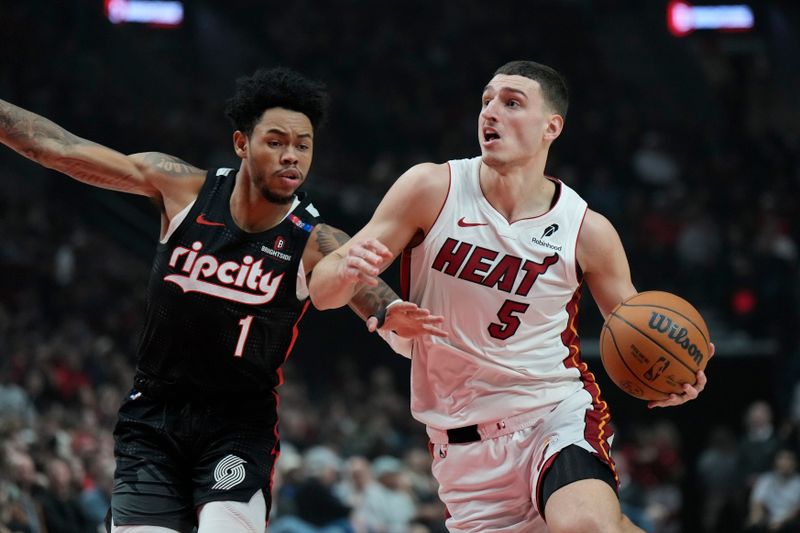 PORTLAND, OREGON - JANUARY 11: Nikola Jovic #5 of the Miami Heat dribbles the ball against Anfernee Simons #1 of the Portland Trail Blazers during the first half at Moda Center on January 11, 2025 in Portland, Oregon. NOTE TO USER: User expressly acknowledges and agrees that, by downloading and or using this photograph, User is consenting to the terms and conditions of the Getty Images License Agreement. (Photo by Soobum Im/Getty Images)