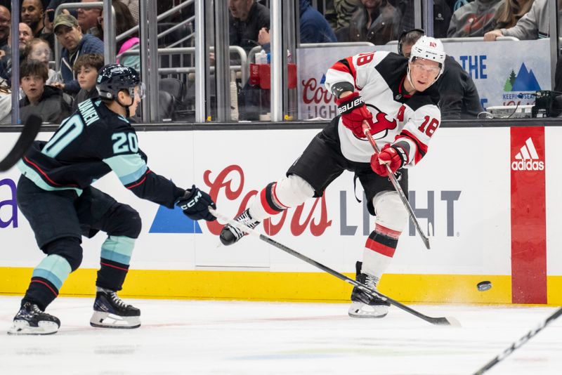 Dec 7, 2023; Seattle, Washington, USA; New Jersey Devils forward Timo Meier (28) passes the puck against Seattle Kraken forward Eeli Tolvanen (20) during the first period at Climate Pledge Arena. Mandatory Credit: Stephen Brashear-USA TODAY Sports