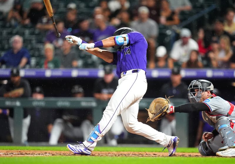 Aug 28, 2024; Denver, Colorado, USA; Colorado Rockies shortstop Ezequiel Tovar (14) loses his bat in the fifth inning against the Miami Marlins at Coors Field. Mandatory Credit: Ron Chenoy-USA TODAY Sports