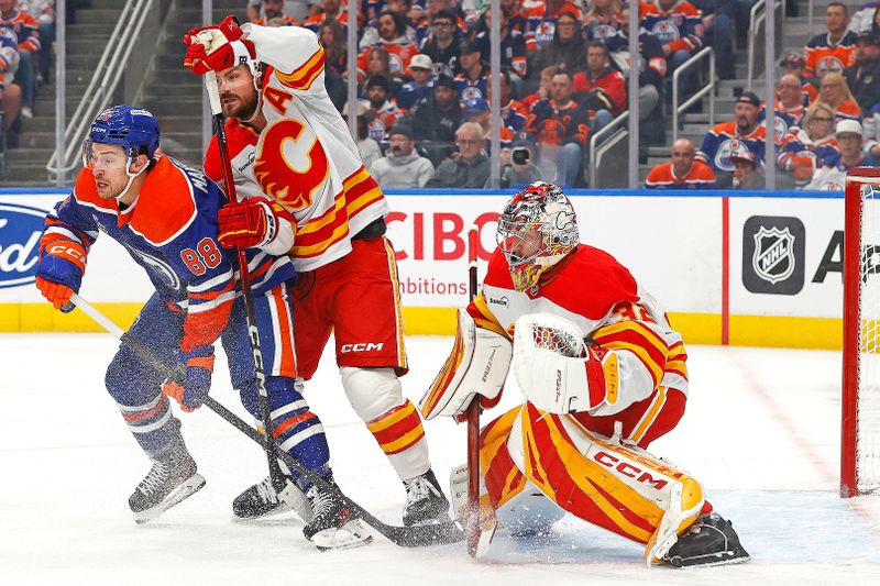 Oct 8, 2025; Edmonton, Alberta, CAN; Edmonton Oilers forward Andrew Mangiapane (88) battles with Calgary Flames defensemen Rasmus Andersson (4) in front of goaltender Dustin Wolf (32) during the first period at Rogers Place. Mandatory Credit: Perry Nelson-Imagn Images