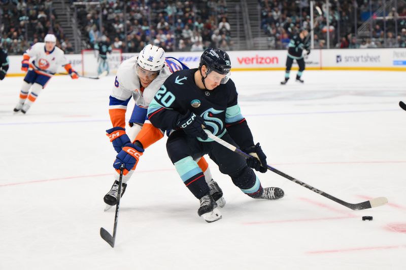 Nov 16, 2024; Seattle, Washington, USA; Seattle Kraken right wing Eeli Tolvanen (20) plays the puck while defended by New York Islanders defenseman Isaiah George (36) during the first period at Climate Pledge Arena. Mandatory Credit: Steven Bisig-Imagn Images