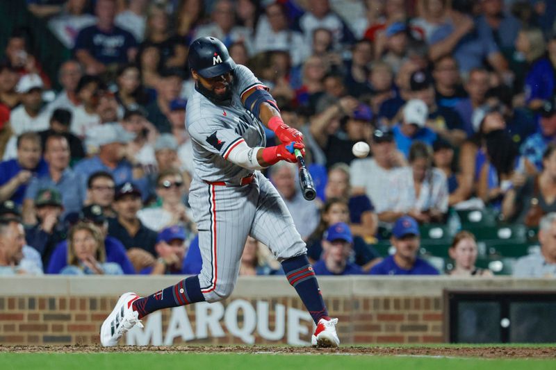 Aug 5, 2024; Chicago, Illinois, USA; Minnesota Twins outfielder Manuel Margot (13) hits a solo home run against the Chicago Cubs during the fifth inning at Wrigley Field. Mandatory Credit: Kamil Krzaczynski-USA TODAY Sports