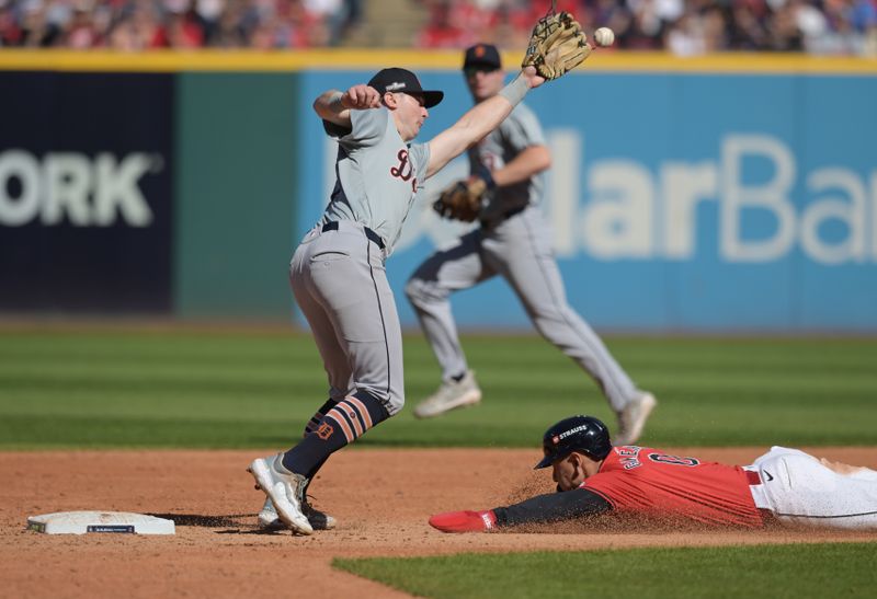 Oct 5, 2024; Cleveland, Ohio, USA; Cleveland Guardians second baseman Andres Gimenez (0) steals second base ahead of Detroit Tigers shortstop Trey Sweeney (27) in the third inning in game one of the ALDS for the 2024 MLB Playoffs at Progressive Field. Mandatory Credit: Ken Blaze-Imagn Images