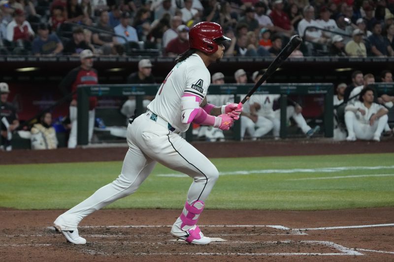 May 18, 2025; Phoenix, Arizona, USA; Arizona Diamondbacks second base Ketel Marte (4) hits a single against the Colorado Rockies in the fifth inning at Chase Field. Mandatory Credit: Rick Scuteri-Imagn Images