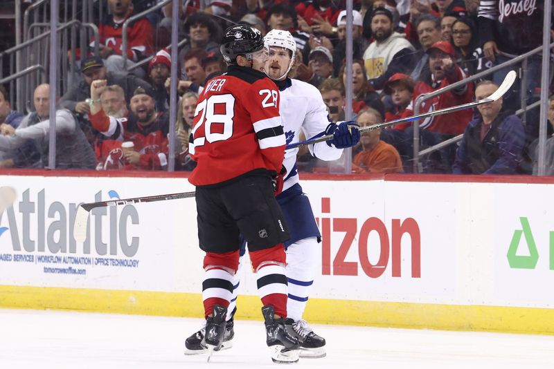 Oct 10, 2024; Newark, New Jersey, USA; Toronto Maple Leafs defenseman Simon Benoit (2) hits New Jersey Devils right wing Timo Meier (28) during the third period at Prudential Center. Mandatory Credit: Ed Mulholland-Imagn Images