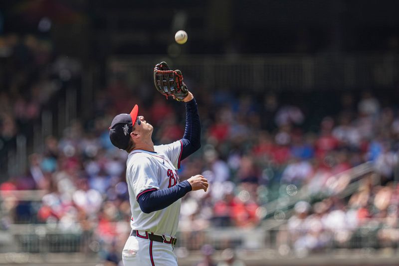 Apr 23, 2025; Cumberland, Georgia, USA; Atlanta Braves third base Austin Riley (27) catches a pop up hit by St. Louis Cardinals outfielder Lars Nootbaar (21) (not shown) during the seventh inning at Truist Park. Mandatory Credit: Dale Zanine-Imagn Images