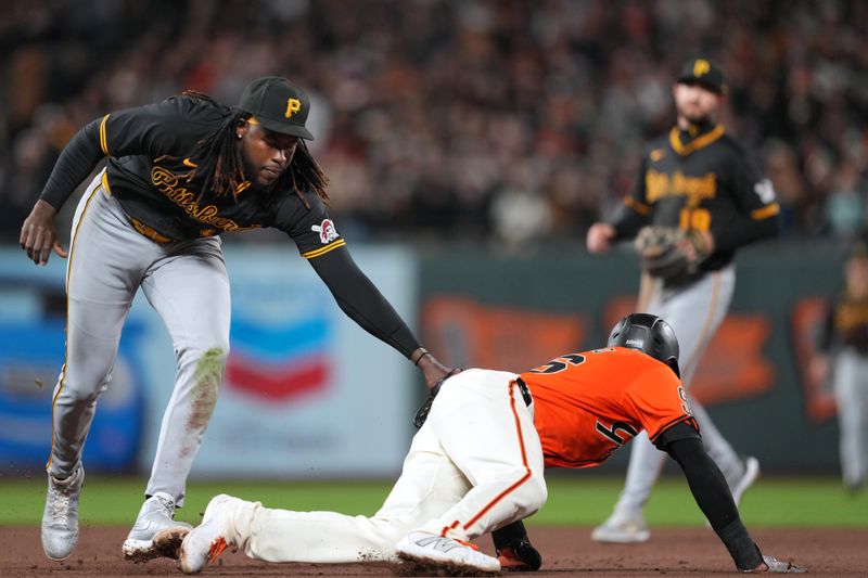 Apr 26, 2024; San Francisco, California, USA; Pittsburgh Pirates shortstop Oneil Cruz (left) tags out San Francisco Giants shortstop Nick Ahmed (on ground) after a pickoff play during the eighth inning at Oracle Park. Mandatory Credit: Darren Yamashita-USA TODAY Sports