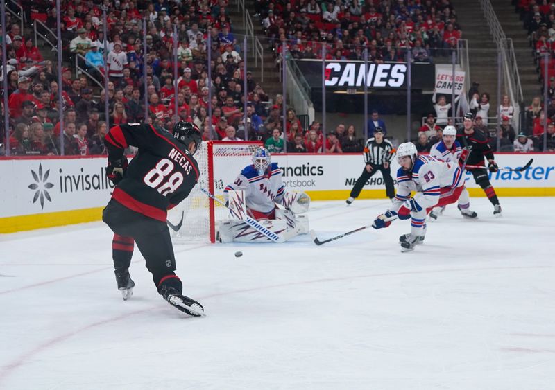 Nov 27, 2024; Raleigh, North Carolina, USA;  Carolina Hurricanes center Martin Necas (88) takes a shot on New York Rangers goaltender Igor Shesterkin (31) during the third period at Lenovo Center. Mandatory Credit: James Guillory-Imagn Images