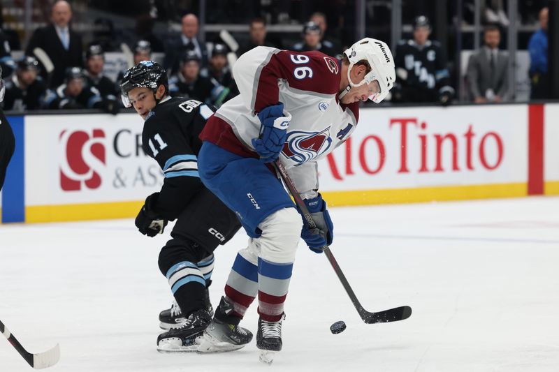 Oct 24, 2024; Salt Lake City, Utah, USA; Colorado Avalanche right wing Mikko Rantanen (96) moves the puck away from Utah Hockey Club right wing Dylan Guenther (11) during the first period at Delta Center. Mandatory Credit: Rob Gray-Imagn Images