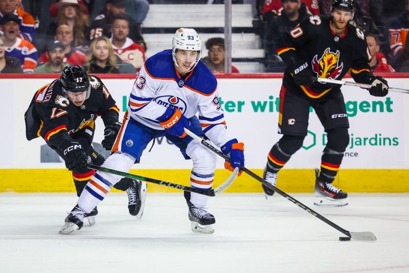 Apr 6, 2024; Calgary, Alberta, CAN; Edmonton Oilers center Ryan Nugent-Hopkins (93) controls the puck against Calgary Flames center Yegor Sharangovich (17) during the first period at Scotiabank Saddledome. Mandatory Credit: Sergei Belski-USA TODAY Sports