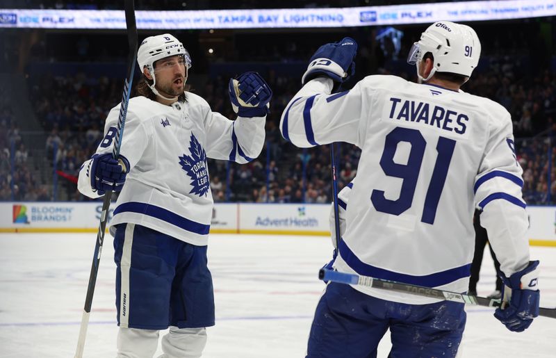 Nov 30, 2024; Tampa, Florida, USA; Toronto Maple Leafs defenseman Chris Tanev (8) is congratulated by center John Tavares (91) after he scored a goal against the Tampa Bay Lightning during the second period at Amalie Arena. Mandatory Credit: Kim Klement Neitzel-Imagn Images