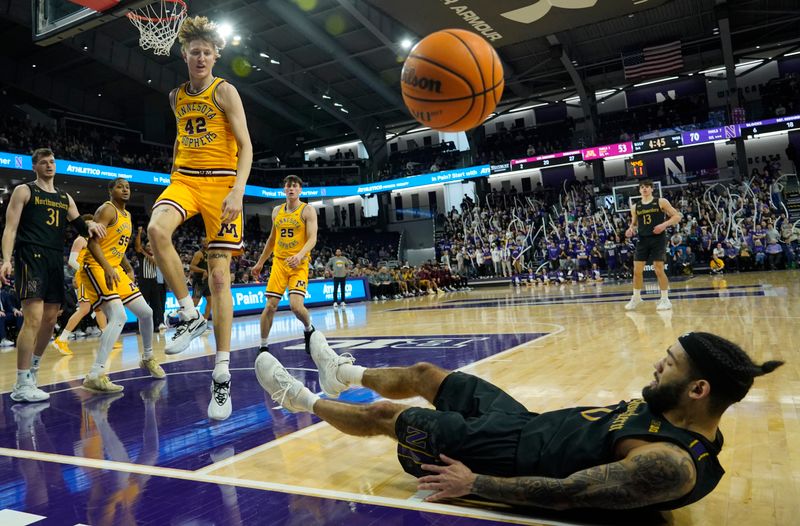 Jan 28, 2023; Evanston, Illinois, USA; Minnesota Golden Gophers center Treyton Thompson (42) fouls Northwestern Wildcats guard Boo Buie (0) during the second half at Welsh-Ryan Arena. Mandatory Credit: David Banks-USA TODAY Sports