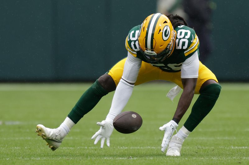 Green Bay Packers linebacker De'Vondre Campbell (59) recovers a fumble lost by Los Angeles Rams quarterback Brett Rypien (11) during the first half of an NFL football game Sunday, Nov. 5, 2023, in Green Bay, Wis. (AP Photo/Matt Ludtke)