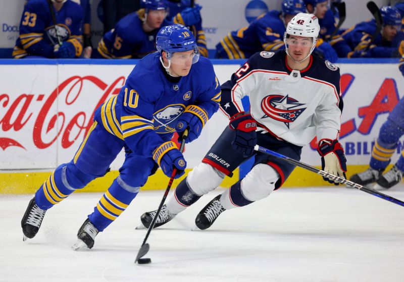 Dec 30, 2023; Buffalo, New York, USA;  Columbus Blue Jackets center Alexandre Texier (42) watches as Buffalo Sabres defenseman Henri Jokiharju (10) skates with the puck during the third period at KeyBank Center. Mandatory Credit: Timothy T. Ludwig-USA TODAY Sports