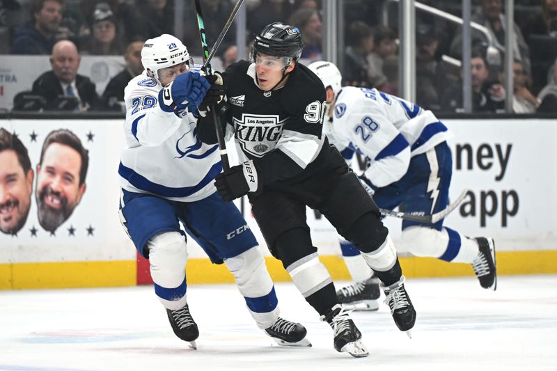 Jan 1, 2026; Los Angeles, California, USA; Tampa Bay Lightning right wing Pontus Holmberg (29) and Los Angeles Kings left wing Andrei Kuzmenko (96) battle for position on the ice during the second period at Crypto.com Arena. Mandatory Credit: Griffin Hooper-Imagn Images